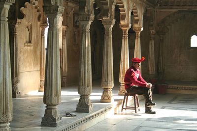 Full length of woman sitting outside building
