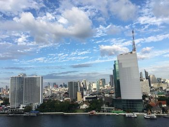 Buildings in city against cloudy sky