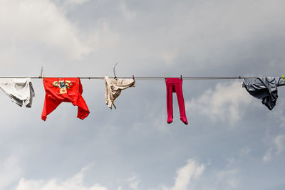 Low angle view of clothes drying on rope against sky