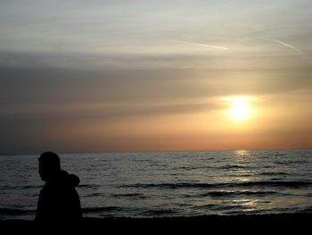 Silhouette of people on beach at sunset