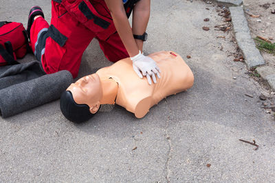 Midsection of paramedic performing cpr on mannequin