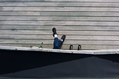 Man sitting on bench against wall