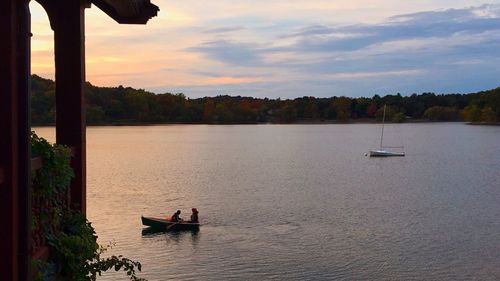 Boat sailing on river against dramatic sky