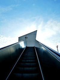 Low angle view of escalator against sky