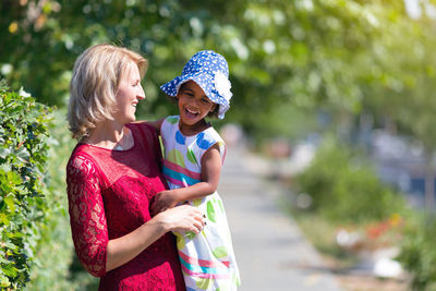 Cheerful mother and daughter in park