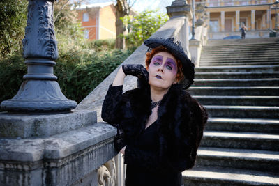 Portrait of beautiful young woman standing on staircase