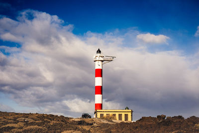 Low angle view of lighthouse against cloudy sky