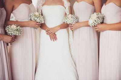 Midsection of bride with bridesmaid