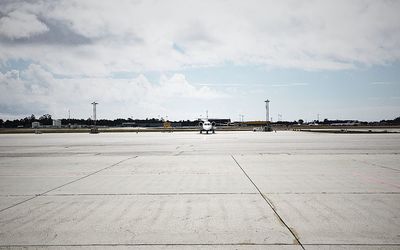 Airplane on airport runway against sky