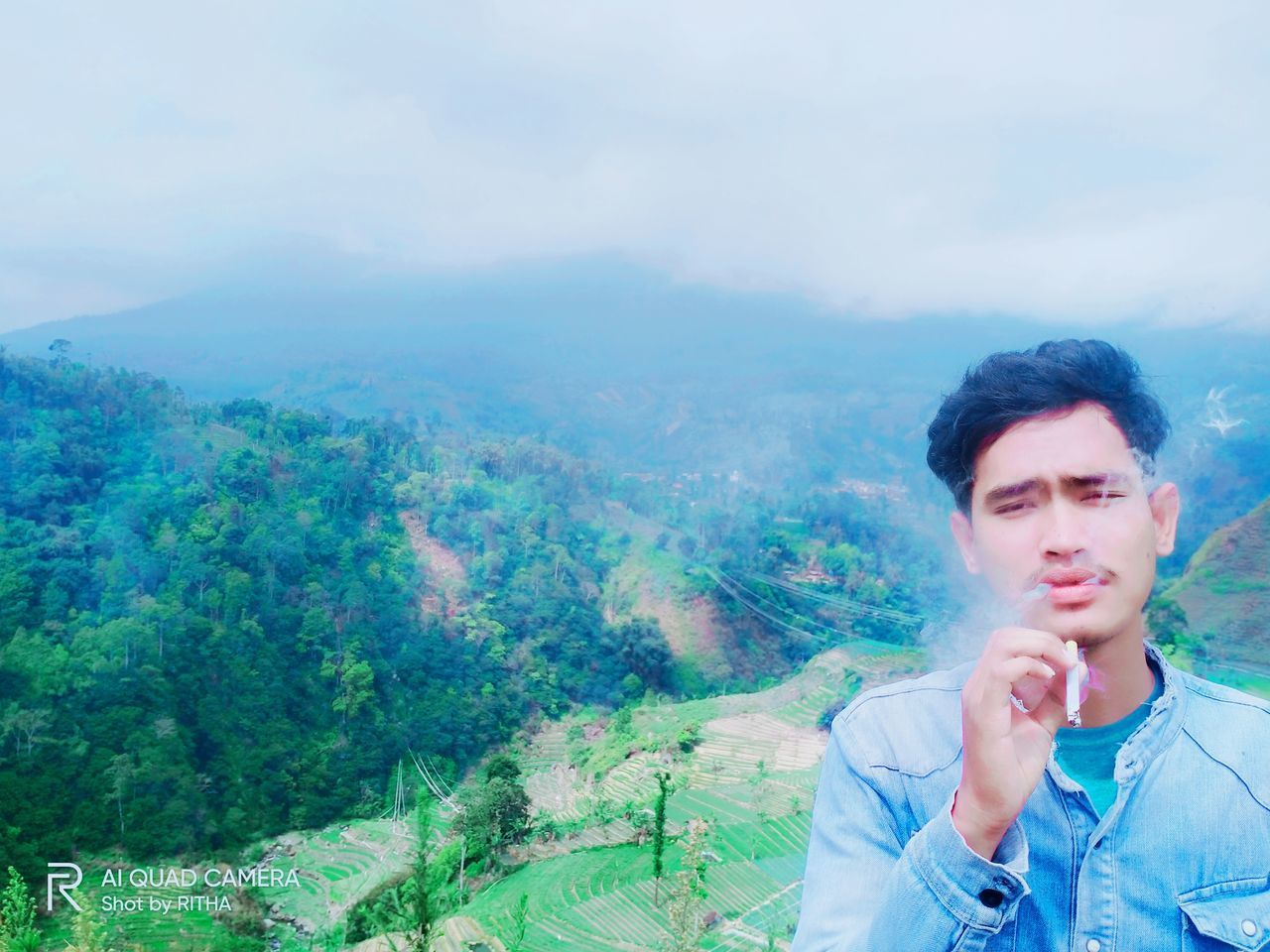 PORTRAIT OF YOUNG MAN LOOKING AT MOUNTAINS