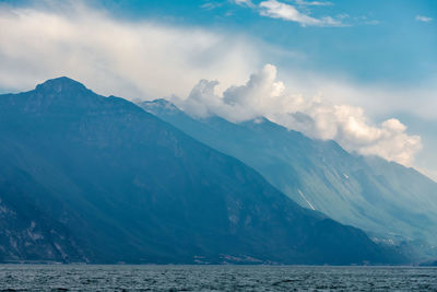 Scenic view of sea and mountains against sky