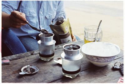 Midsection of man making coffee on bright day