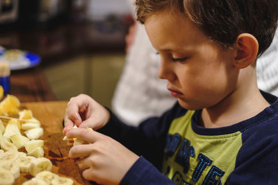 Close-up of boy with fruits at table