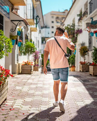 Rear view of man walking on footpath