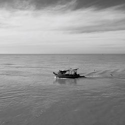 Boat sailing in sea against sky