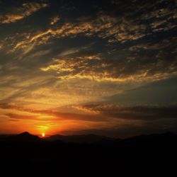 Scenic view of silhouette mountains against sky during sunset