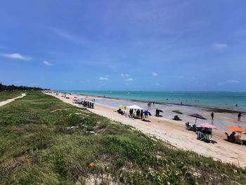 People on beach against sky