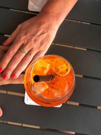 Close-up of hand holding drink on table