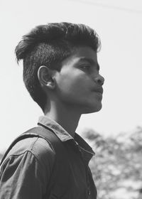 Profile view of thoughtful young man standing against clear sky