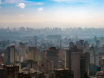 Aerial view of buildings in city against sky