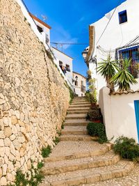 Alley amidst houses against sky