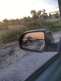 Car on country road by field against sky