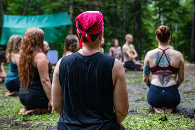 Rear view of people sitting on land