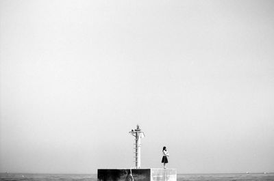 Woman standing on pier against sky