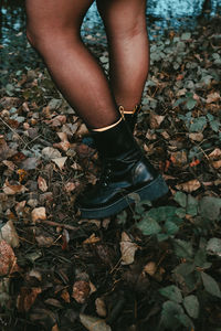 Low section of woman standing on ground during autumn