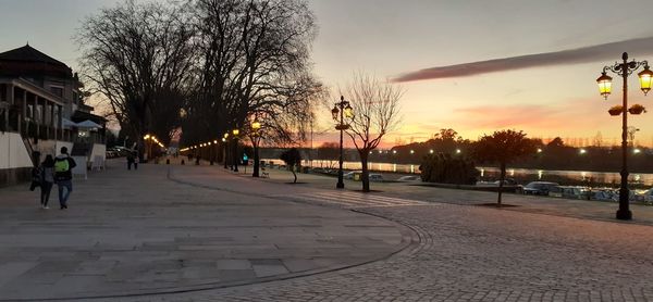 Street amidst buildings against sky during sunset