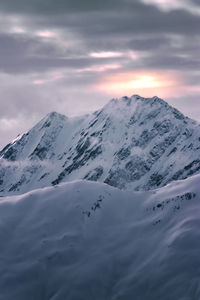 Scenic view of snowcapped mountains against sky during sunset