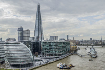 Modern buildings in city against cloudy sky