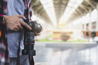 Midsection of man holding camera