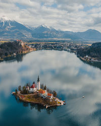 High angle view of city by mountains against sky