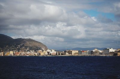 River in city against cloudy sky