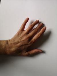 Close-up of hand over white background