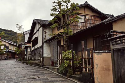 Houses by street in town against sky