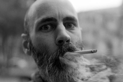 Close-up portrait of man smoking cigarette