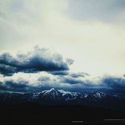 Scenic view of mountains against cloudy sky