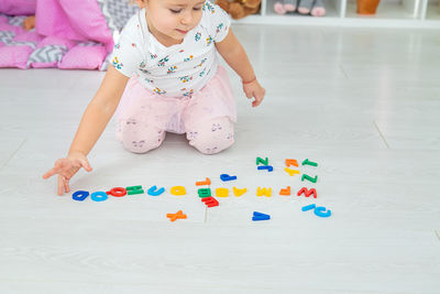 Portrait of cute girl playing with toy on floor