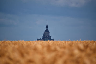 Tower on field against sky