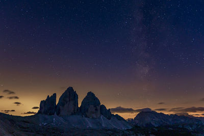 Scenic view of snowcapped mountains against sky at night