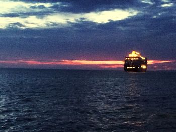 Boats in sea at sunset