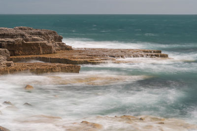 Long exposure of the tide flowing over rocks at portland bill in dorset