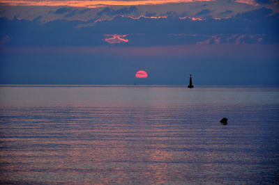 Scenic view of calm sea against cloudy sky