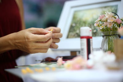 Midsection of woman making artificial flowers