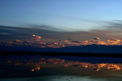 Scenic view of lake against sky during sunset