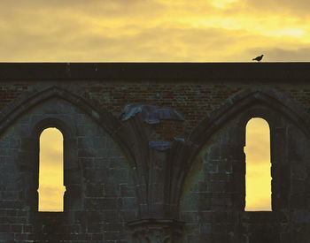 Arch in city against sky during sunset