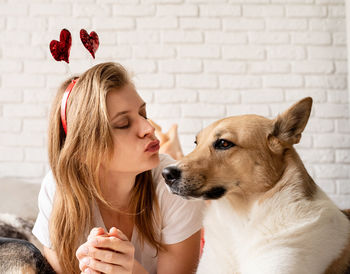 Lovely pet. young woman with her cute shepherd at home having fun and kissing, funny picture