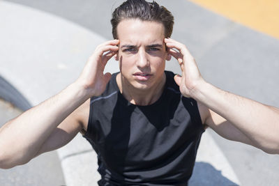 Confident young man exercising during sunny day